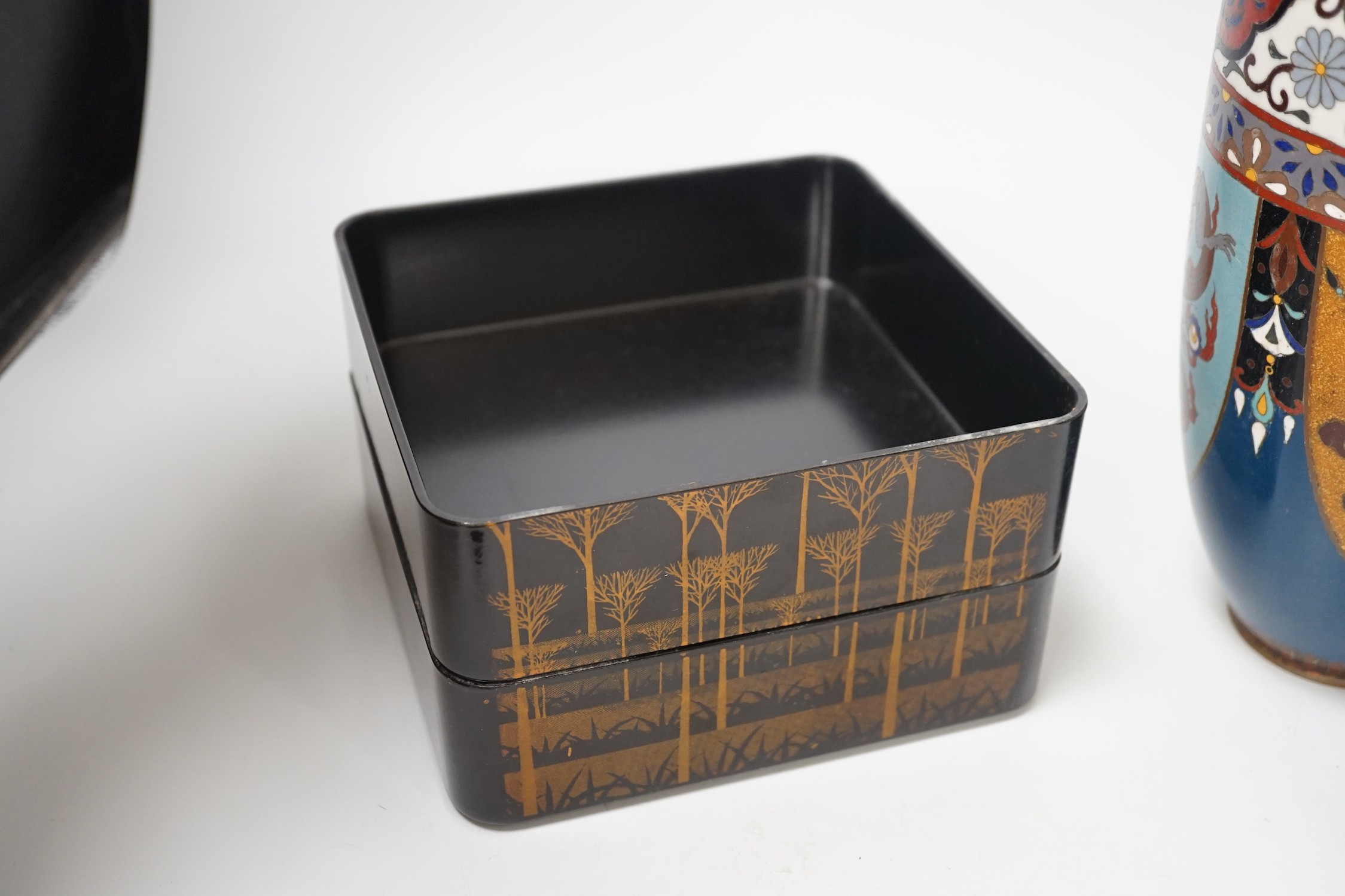 A large Japanese cloisonné enamel vase, 30.5cm high, a similar jar and cover and a Japanese lacquered tiered box with 3-4 drawers. Tree design in gold lacquer.